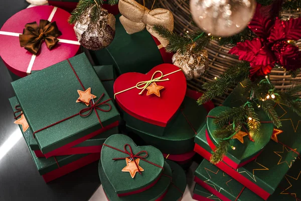 beautifully packaged gifts under the Christmas tree. green and red boxes with surprises from santa claus under the tree. christmas and happy new year
