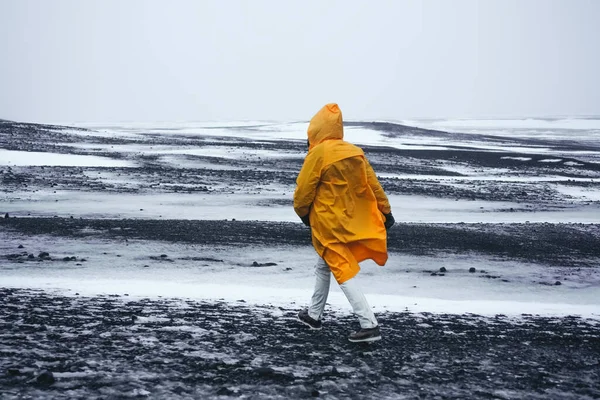 비옷을 소녀가 눈덮인 들판을 지릅니다 겨울에는 아이슬란드의 자연에 영향을 않는다 — 스톡 사진