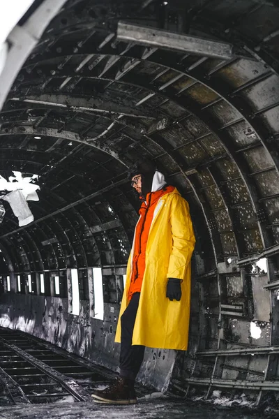 man in yellow raincoat inside DC-3 plane crashed in Slheimasandur. Attractions of Iceland. Iceland, December 2020