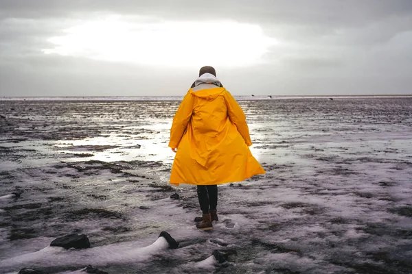 비옷을 남자가 눈덮인 들판을 지릅니다 겨울에는 아이슬란드의 자연에 영향을 않는다 — 스톡 사진