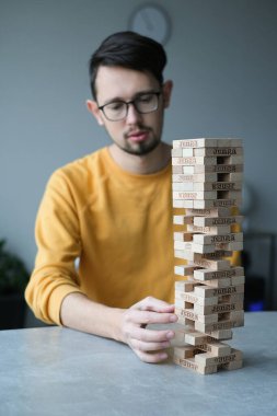 Delikanlı kendini izole ederek evde Jenga oynuyor. Ev eğlencesi. Boş zaman. Roma, İtalya Aralık 2020