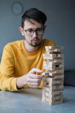 Delikanlı kendini izole ederek evde Jenga oynuyor. Ev eğlencesi. Boş zaman. Roma, İtalya Aralık 2020