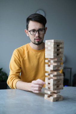 Delikanlı kendini izole ederek evde Jenga oynuyor. Ev eğlencesi. Boş zaman. Roma, İtalya Aralık 2020
