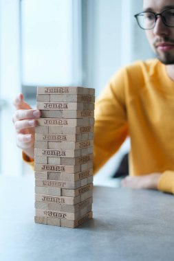 Delikanlı kendini izole ederek evde Jenga oynuyor. Ev eğlencesi. Boş zaman. Roma, İtalya Aralık 2020