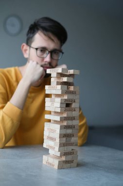 Delikanlı kendini izole ederek evde Jenga oynuyor. Ev eğlencesi. Boş zaman. Roma, İtalya Aralık 2020