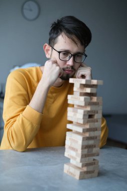Delikanlı kendini izole ederek evde Jenga oynuyor. Ev eğlencesi. Boş zaman. Roma, İtalya Aralık 2020