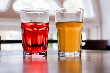 İki bardak portakal suyu ve nar suyu bir kafede masanın üstünde. Sağlıklı içecekler, içecekler, limonata ve limonata. Soğuk içecekler. Detoks