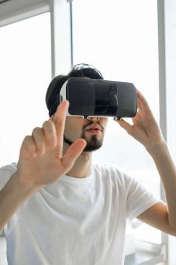 Genç bir adam güçlü bir şekilde sanal gerçeklik video oyunu oynuyor ve VR gözlük takıyor. Adam video oyunları oynuyor. Biraz rahatla. Neşeli bir hafta sonu. Çoklu oyuncu oyunu. Çevrimiçi oyunlar. Canlı video oyunları.