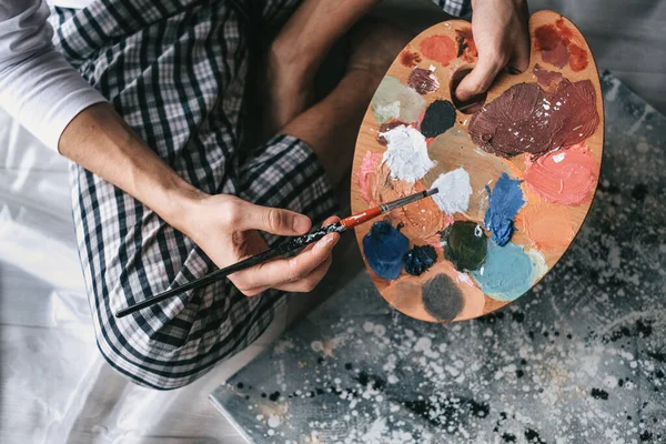 年轻人在木制调色板上混合油画 在家里画一幅自我隔离的画 艺术疗法 家庭休闲 艺术工作坊 — 图库照片