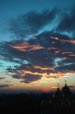 Hıristiyan Ortodoks Kilisesi güzel bir günbatımının arka planında. Kırmızı-turuncu güneş ufuktan batıyor ve kiliseyi aydınlatıyor. Katalan Kilisesi. inanç ve din