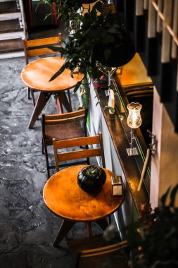 Kafe manzaralı iki kişilik yuvarlak masa. Aile restoranının rahat yeri. Nefis akşam yemeği olan şirin bir kafe.