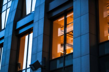 Akşamları modern iş merkezi binası. İş merkezinde ışıkları açık olan pencereler. Mesai saati. Ukrayna, Kyiv Ekim 2020