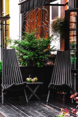 Kafe teras masasında iki hasır sandalye var. Şehir kafesi manzarası. Sıcak aile kafesi..