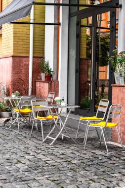 Kafe teras masasında iki hasır sandalye var. Şehir kafesi manzarası. Sıcak aile kafesi. Vozdvyzhenska Caddesi, Kiev, Ukrayna Kasım 2020