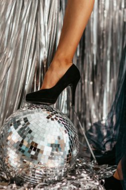 Disko topunda siyah ayakkabılı ince bacak. Disko partisi. Noel süsleri ve süslemeleri