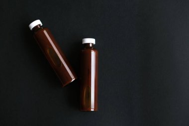 Siyah arka planda sıvı vitamin ampulleri. Siyah arka planda kozmetik ürünü olan şişeler. Cam tıbbi ampuller. maketleme