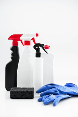 Beyaz arka planda temizlik için kullanılan ev yapımı kimyasallar. Havlu, eldiven, yakın plan deterjanlı şişeler. maketleme