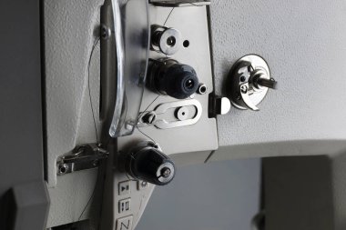 Siyah arka planda yakın plan üretim dikiş makinesi. Profesyonel bir dikiş makinesinin detayları. maketleme