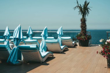 Okyanus kıyısındaki otelde şemsiyeli güneş panzeleri. Kumsalda dinlenmek için turistik bir yer..