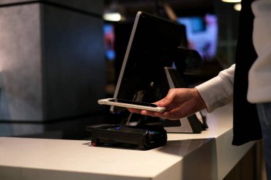 Kadın, dükkandaki telefon aracılığıyla erişimsiz ödeme yapıyor.