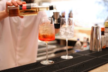 Barmen bardaki restoranda kokteyl hazırlıyor. Ferahlatıcı yaz içkileri. İş yerindeki barmen. maketleme