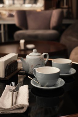 Bir kafede çay seremonisi. Bardaklar ve çaydanlık masanın üzerinde.