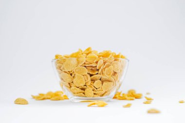 Beyaz arka planda bir tabakta mısır gevreği. Kuru ve çabuk kahvaltı. Amerikan yemekleri.