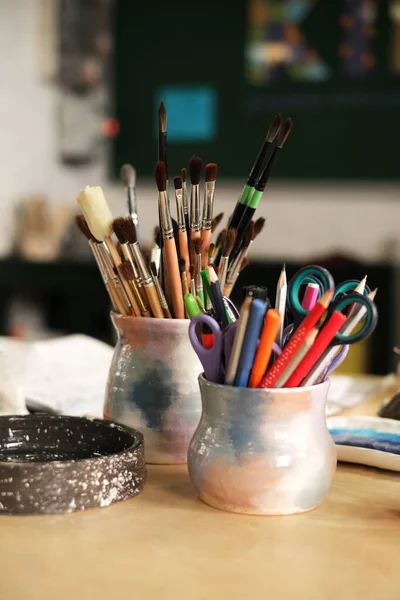 桌面上有刷子的罐子 绘画和陶器硕士课程 创意工作坊 — 图库照片