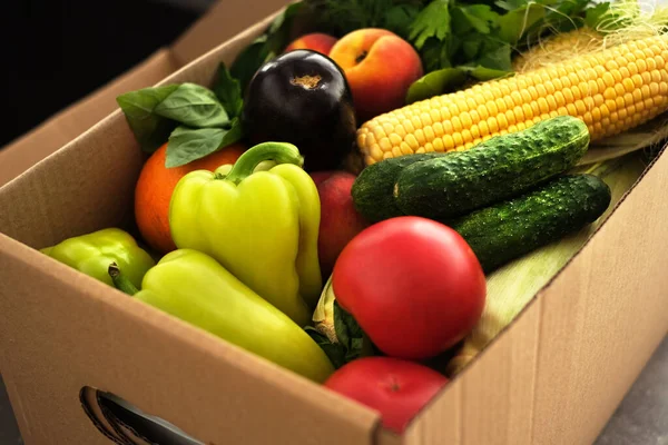 online ordering of products from the online store on the table in the kitchen. vegetables and fruits in a cardboard box on the table top view.