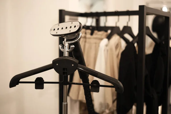 garment steamer in a store close-up. new collection of minimalist clothes in the boutique