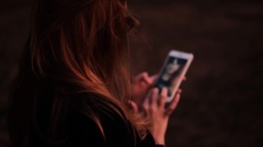 Güzel bir kadın ormanda telefonda selfie çekiyor. blog yazarı içeriği vuruyor