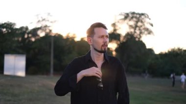 Güneş gözlüklü ve güneş batarken gözlük takan yakışıklı bir esmer adamın portresi.