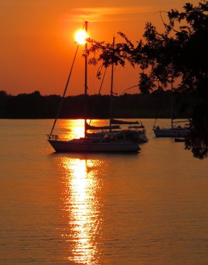Bir göl üzerinde günbatımında yelkenli