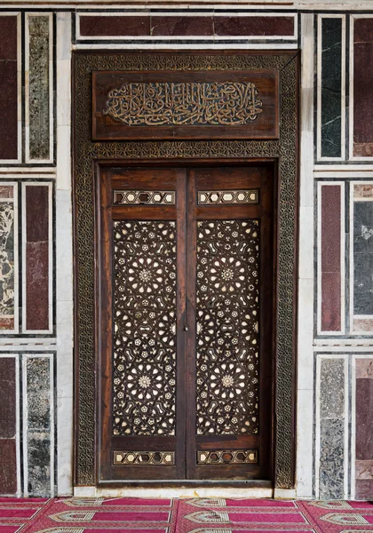 Antigua pared de mármol decorado con una puerta de madera ornamentada histórica — Foto de Stock