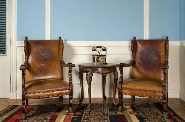 Dos sillones retro de madera, teléfono viejo y mesa redonda — Foto de Stock