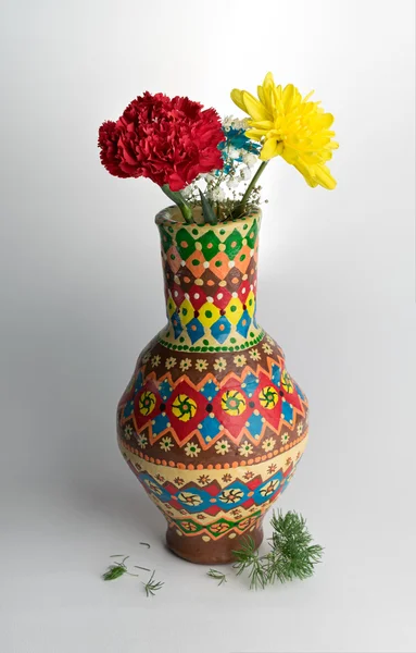 Vaso de cerâmica colorido com duas flores no fundo branco — Fotografia de Stock