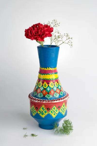 Цветная ваза из керамики с красным цветком на белом фоне — стоковое фото