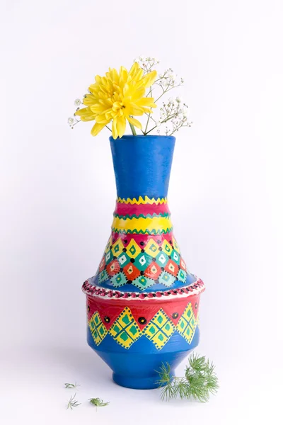Vaso de cerâmica colorido com flor amarela no fundo branco — Fotografia de Stock