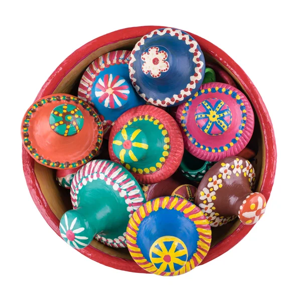 Beyaz zemin üzerinde bir çanak çömlek kapta seramik kapakları yığılmış