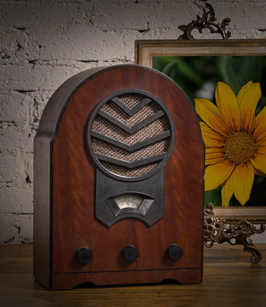 Velho rádio de madeira e pintura moldada de ouro na mesa de madeira — Fotografia de Stock