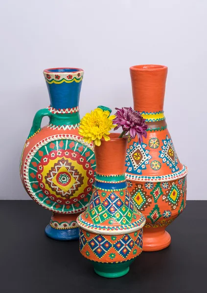Tres jarrones de cerámica ornamentados con dos flores amarillas y violetas — Foto de Stock