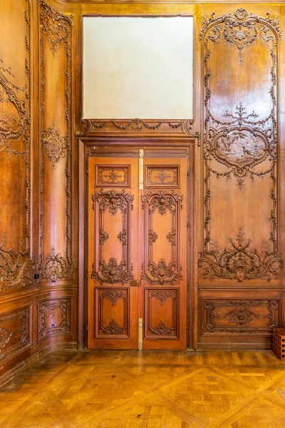 Puerta de madera elegante cerrada con decoraciones grabadas, instalada en arco ornamental de madera —  Fotos de Stock