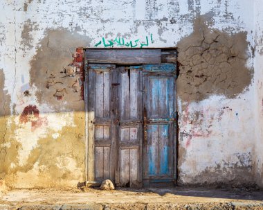 Kapalı terk edilmiş ahşap kapı ve eski püskü grunge duvar