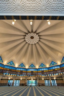 Kuala Lumpur, Malaysia - March 1, 2025: Prayer hall of Masjid Negara, or National Mosque. Highlights its striking fan-like dome, colorful stained glass, and intricate Islamic geometric designs