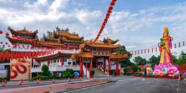 Kuala Lumpur, Malaysia - Feb. 19, 2025: Thean Hou Temple, decorated with red lanterns, a large Mazu statue, and a snake mural. Traditional Chinese architecture under a bright sky.
