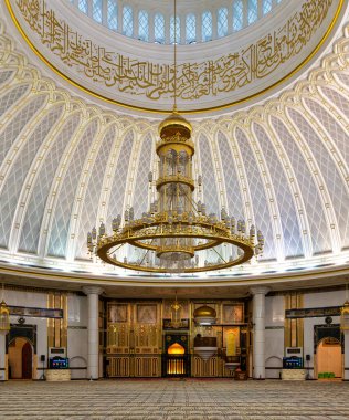 Opulent interior of Jame Asr Hassanil Bolkiah Mosque, Bandar Seri Begawan, Brunei. Features a grand golden chandelier, ornate dome with Arabic calligraphy, and mihrab