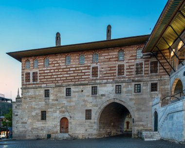 İstanbul, Türkiye 'deki Hunkar Kasri veya Sultanlar Pavyonu. Osmanlı mimarisi; taş ve tuğla duvarlar, kemerli bir geçit ve açık mavi gökyüzünün altında süslü saçaklar.