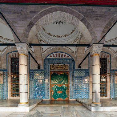 Rustem Paşa Camii 'nin avlu manzarası, İstanbul, Türkiye. Karmaşık Iznik fayansları, büyük mermer kolonlar, kemerler ve yeşil giriş perdesi. Tarihi Osmanlı mimarisi