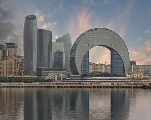 Modern Bakü, Azerbaycan silueti ikonik Crescent Otel ve Hilal Kulesi ile diğer gökdelenler, yumuşak ve bulutlu bir gökyüzünün altında Hazar Denizi 'ne yansıyor..