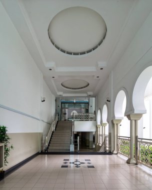 El-Buhari Vakfı Camii, Kuala Lumpur, Malezya. Geniş bir koridor, büyük merdiven, kemerli pencereler, süslü korkuluklar ve geometrik döşemeli dekoratif tavan..